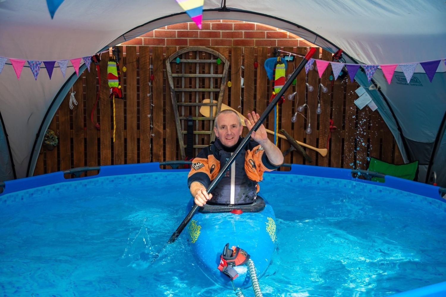 A man paddling a kayak in a swimming pool
