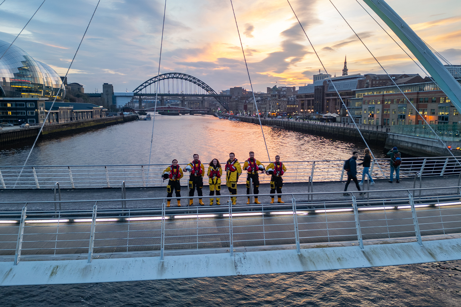 A group of RNLI crew stood on the Tyne bridge. 
