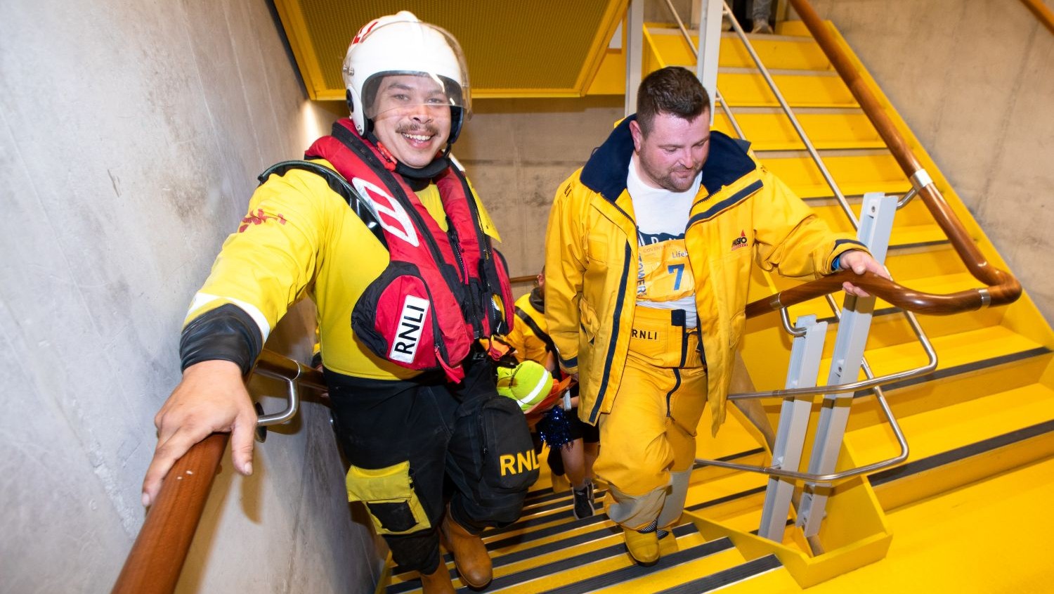 RNLI crew members walking up the Tower of London stairwell.